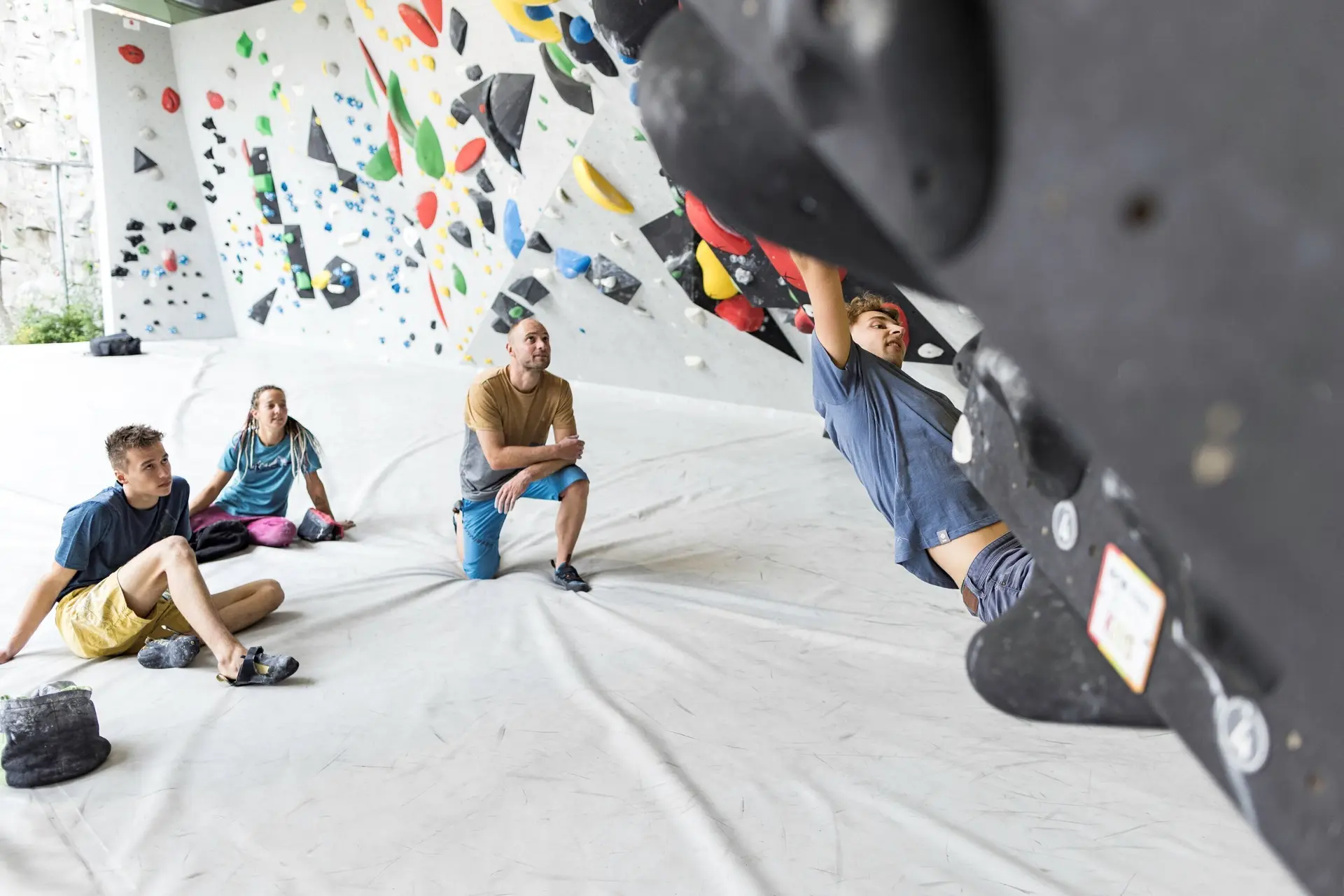 Ein Mann beim Bouldern, im Hintergrund warten weitere Personen, bis sie an der Reihe sind | © DAV / Jens Klatt